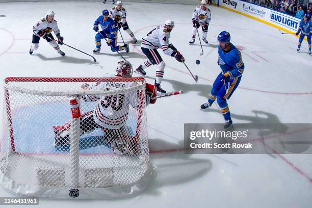 Jaxson Stauber and Seth Jones of the Chicago Blackhawks defend the net against Pavel Buchnevich of the St. Louis Blues at the Enterprise Center on...