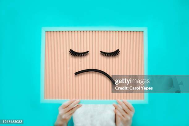 unrecognizable person holding a sign with sad face drawing on it - sad face drawing - fotografias e filmes do acervo