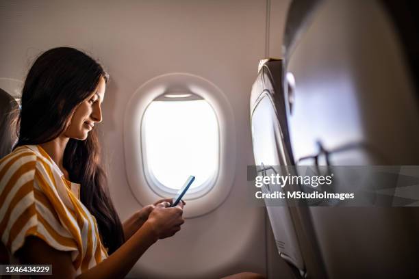 woman traveling with airplane. - mobile on plane stock pictures, royalty-free photos & images