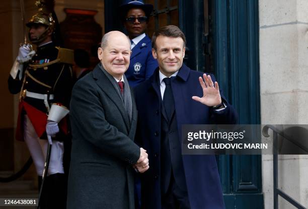 France's President Emmanuel Macron shakes hands with German Chancellor Olaf Scholz as they arrive to attend a ceremony as part of the celebration of...
