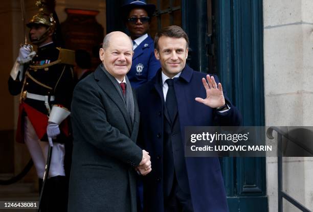 France's President Emmanuel Macron shakes hands with German Chancellor Olaf Scholz as they arrive to attend a ceremony as part of the celebration of...