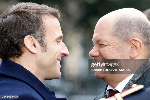France's President Emmanuel Macron welcomes German Chancellor Olaf Scholz as he arrives to attend a ceremony as part of the celebration of the 60th...