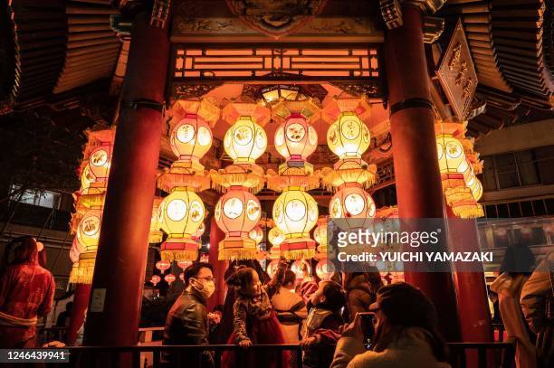 People take photographs next to lanterns in the Chinatown area of Yokohama on January 22 on the first day of the lunar new year.