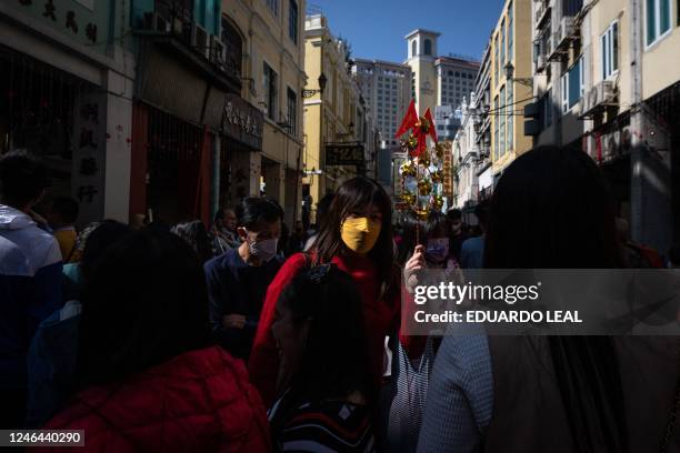 Pedestrians walk along San Ma Lo avenue during celebrations on the first day of the Chinese lunar new year in Macau on January 22, 2023.