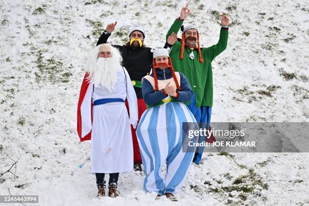 Supporters costumed as Asterix and Obelix comic book characters react during the men's competition of the FIS Ski World Cup in Kitzbuehel, Austria,...