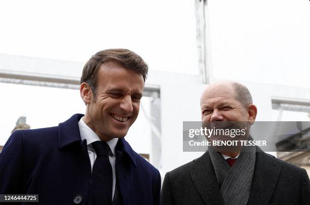 France's President Emmanuel Macron and German Chancellor Olaf Scholz share a laugh during a joint cabinet meeting presenting Franco-German industrial...