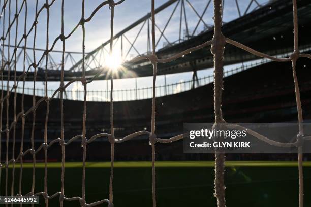 Seen through the net, sunshine falls on the pitch ahead of the English Premier League football match between Arsenal and Manchester United at the...