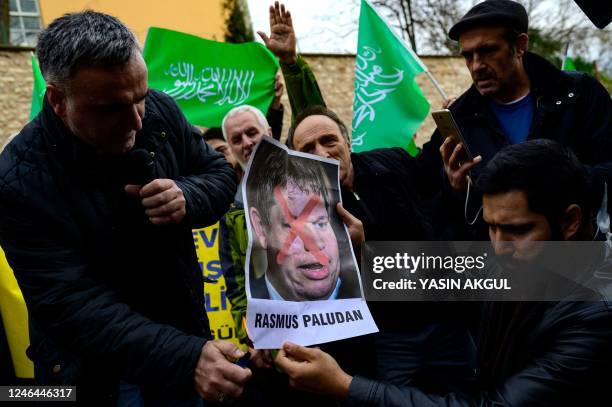 Protesters burn a portrait of Rasmus Paludan, leader of Danish far-right political party Hard Line, in front of the Consulate General of Sweden in...