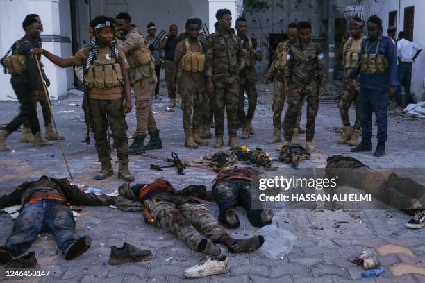 Graphic content / TOPSHOT - Police officers stand near the bodies of alleged Al-Shabaab militants who have been killed after the siege at the...