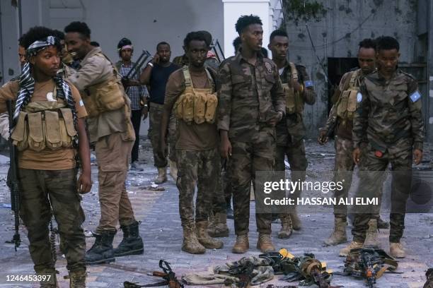 Police officers stand near the bodies of alleged Al-Shabaab militants who have been killed after the siege at the Mogadishu Municipality Headquaters...