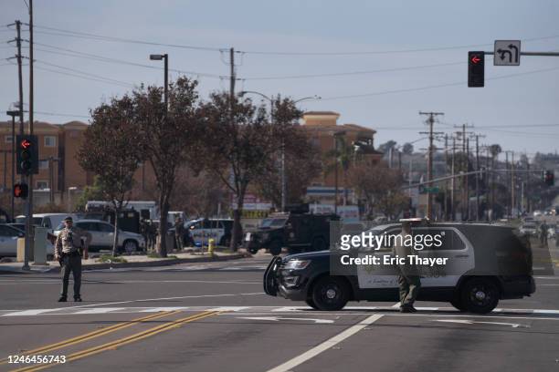 Law enforcement surround a white van in a parking lot that is being investigated for a possible connection to the earlier Monterey Park mass shooting...