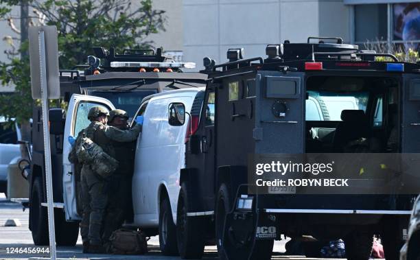 Law enforcement personnel open the door of a van outside the site in Torrance, California, where the alleged suspect in the mass shooting in which 10...