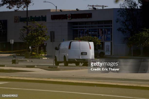 Law enforcement surround a white van in a parking lot that is being investigated for a possible connection to the earlier Monterey Park mass shooting...