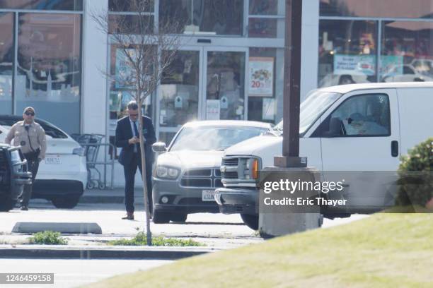 Law enforcement surrounds a white van in a parking lot that is being investigated for a possible connection to the earlier Monterey Park mass...