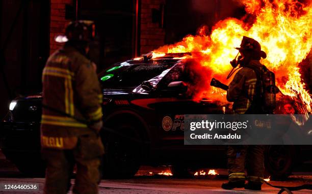 Firefighters work to extinguish a fire after an Atlanta police vehicle was set on fire during a "Stop cop city" protest in Atlanta, Georgia, United...