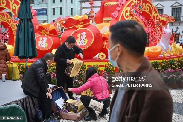 This photo taken on January 17, 2023 shows tourists from mainland China packing souvenirs into suitcases in the southern Chinese enclave of Macau. -...