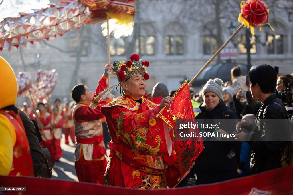 A performer dressed in the costume of the Money God wishes...