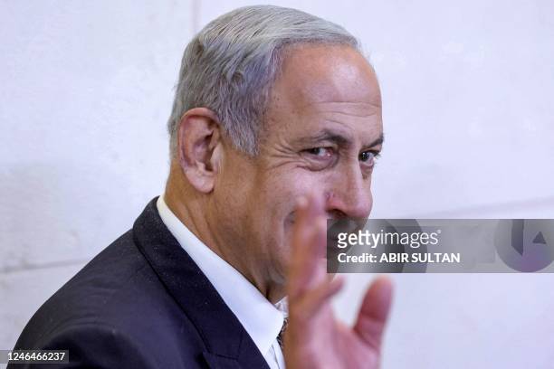 Israeli Prime Minister Benjamin Netanyahu waving as he walks during a hearing at the Magistrate's Court in Rishon Lezion on January 23, 2023. - The...