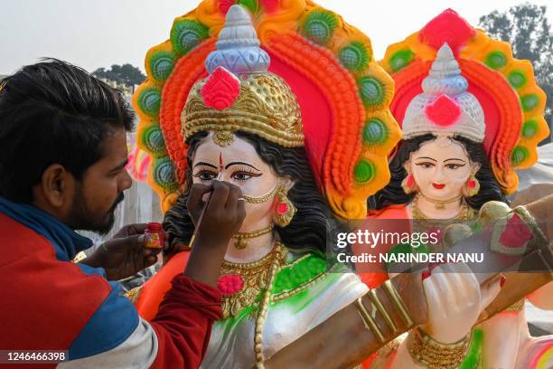 An artist paints an idol of the Hindu goddess Saraswati ahead of the 'Basant Panchami' festival, on the outskirts of Amritsar on January 23, 2023.