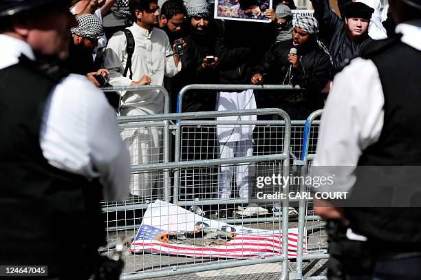 Piece of paper bearing an image of the US flag is burnt around the time of a one minute silence at the US embassy in central London on September 11...