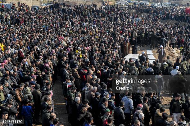 Mourners gather in a cemetery to attend the funeral for victims of a building which collapsed the day before in Syria's war-damaged northern city of...