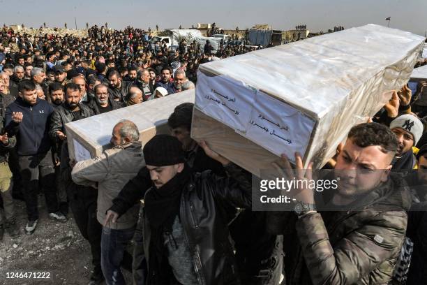 Mourners carry the boxes containing the bodies of victims of a building which collapsed the day before, during the burial in a cemetery in Syria's...