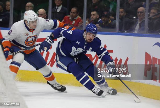 Toronto Maple Leafs center Auston Matthews figts off New York Islanders defenseman Ryan Pulock as the Toronto Maple Leafs play the New York Islanders...