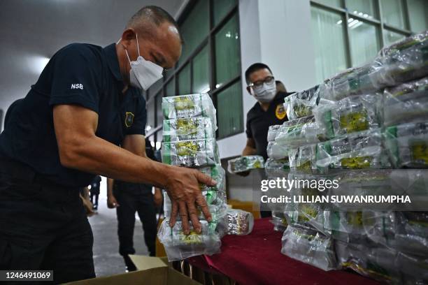 Personnel from the Narcotic Suppression Division handle packages of crystal methamphetamine after a press conference at the Narcotics Suppression...