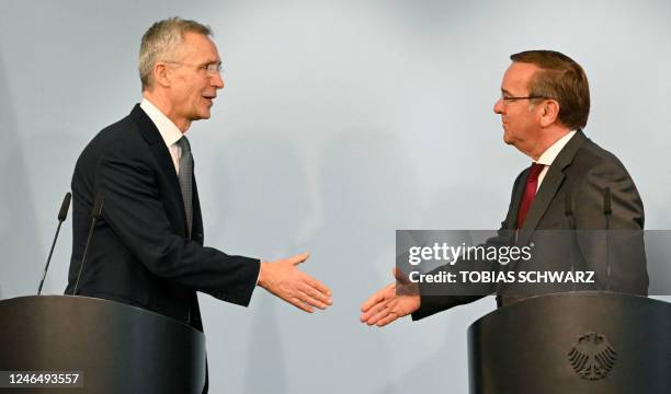 Germany's new Defence Minister Boris Pistorius shakes hands with NATO chief Jens Stoltenberg after a joint press conference following talks on...