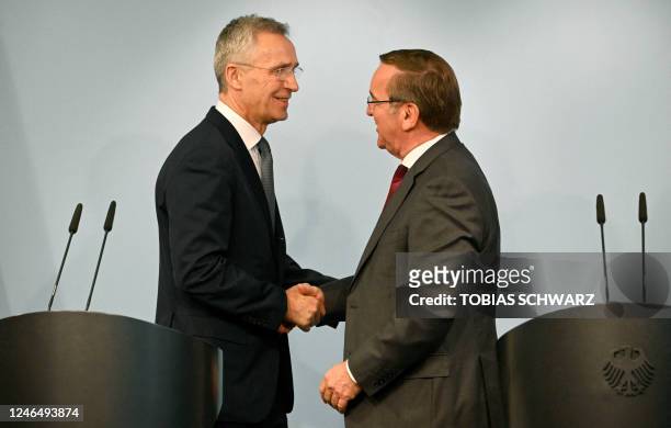 Germany's new Defence Minister Boris Pistorius shakes hands with NATO chief Jens Stoltenberg after a joint press conference following talks on...