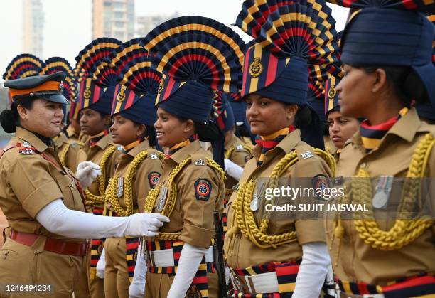 Mumbai police personnel help each other to adjust their uniforms during a rehearsal ahead of the upcoming Republic Day celebrations at Shivaji Park,...