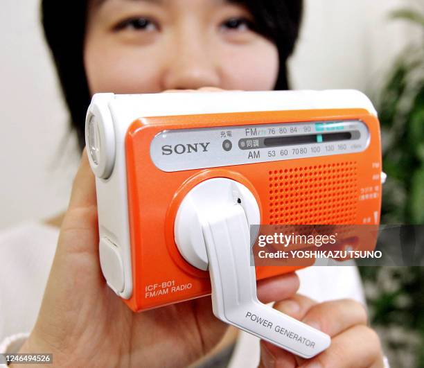 Japanese electronics giant Sony employee Masayo Endo displays the new emergency radio "ICF-B01", equipped with spot and diffused LED lights and...