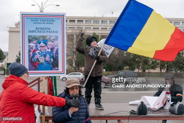 Boy holds a Romanian flag as he attends a rally against the involvement of Romania in the war between Russia and Ukraine, on January 24 in Bucharest,...