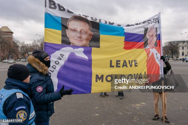 People hold a flag depicting the flags of Ukraine and Russia as well as the Russian President Vladimir Putin and Ukrainian President Volodymyr...