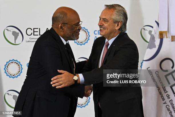 Argentine President Alberto Fernandez shakes hands with Haitian Prime Minister Ariel Henry before the opening of the Community of Latin American and...
