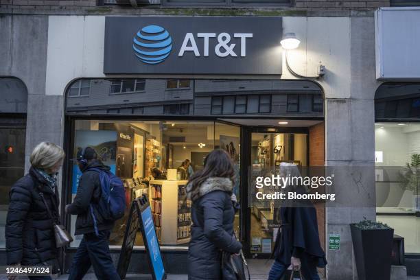 Pedestrians pass an AT&T store in New York, US, on Friday, Jan. 20, 2023. AT&T Inc. Is scheduled to release earnings figures on January 25....