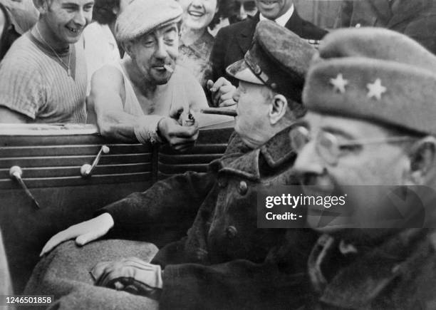 Un Français, en geste bienvenue, offre du feu au Premier ministre britannique sir Winston Churchill, accompagné du général américain Cecil Moore, le...