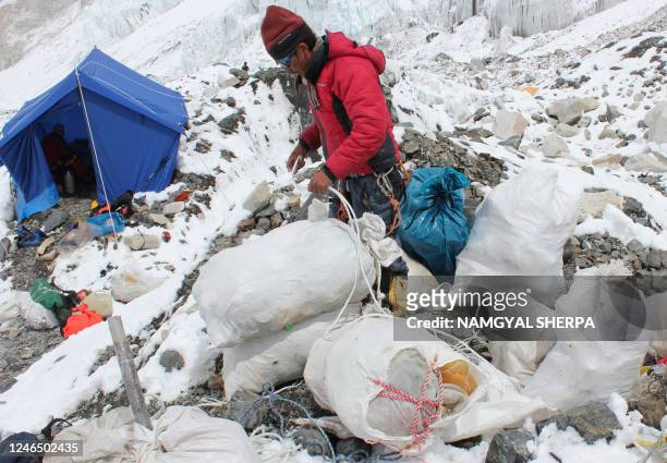 This picture taken on May 26, 2010 shows A Nepalese sherpa packing garbage collected from the Everest clean-up expedition at Everest Base Camp. A...