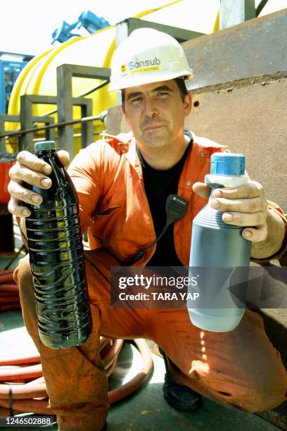 Chris Devries of Sonsub shows two plastic bottles containing samples of oil retrieved from the sunken Solar I, removed by a remote operated vehicle...