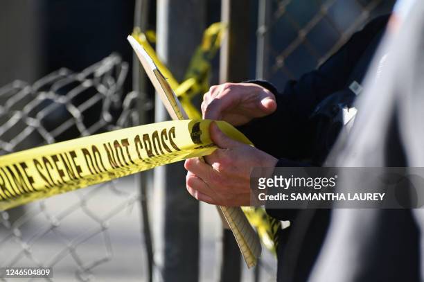 San Mateo County Sheriff officer puts up police tape at a crime scene after a shooting at the Spanish Town shops in Half Moon Bay, California, on...
