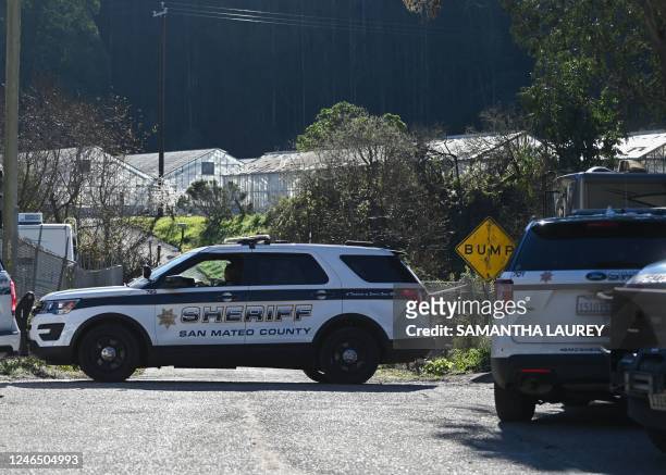 San Mateo County Sheriff officer wait for investigators at a crime scene after a shooting at the Spanish Town shops in Half Moon Bay, California, on...