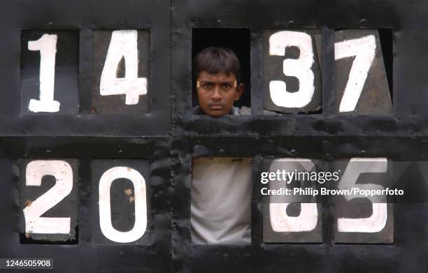 Boy watches the match from a section of the scoreboard showing England's bowling figures on day four of the 2nd Test match between Sri Lanka and...