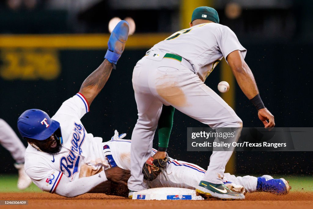 Texas Rangers Andrus Adolis Garcia of the Texas Rangers evades the tag of Elvis Andrus of ...