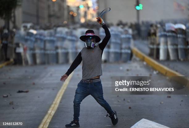 Demonstrator swings a makeshift slingshot during clashes with riot police within a protest against the government of Dina Boluarte asking for her...