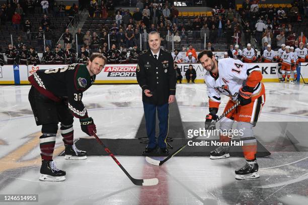 Army Staff Sergeant Kevin Froehler drops the ceremonial puck drop on Military Appreciation Night for Christian Fischer of the Arizona Coyotes and...