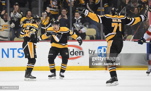 Kris Letang of the Pittsburgh Penguins celebrates with teammates, Sidney Crosby and Evgeni Malkin, after scoring the game winning goal in overtime to...