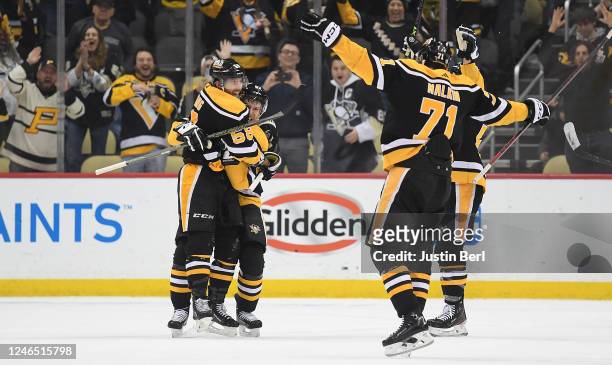 Kris Letang of the Pittsburgh Penguins celebrates with teammates, Sidney Crosby and Evgeni Malkin, after scoring the game winning goal in overtime to...