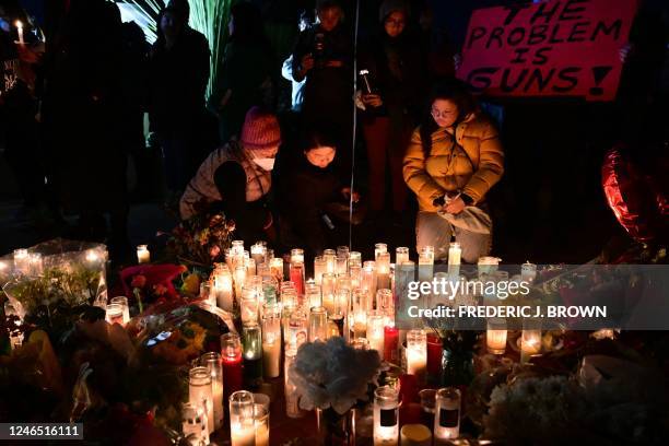 People pay tribute to the victims of the mass shooting at a candlelight vigil in front of City Hall in Monterey Park, California, on January 24,...