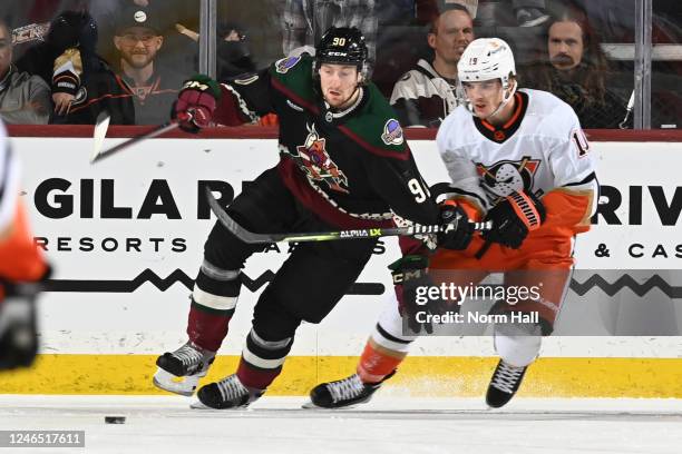Moser of the Arizona Coyotes skates with the puck while being defended by Troy Terry of the Anaheim Ducks during the third period at Mullett Arena on...
