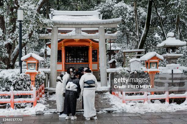 People in traditional attire visit the Yasaka Shrine in Kyoto on January 25 after heavy snow and strong winds overnight affected wide areas of the...